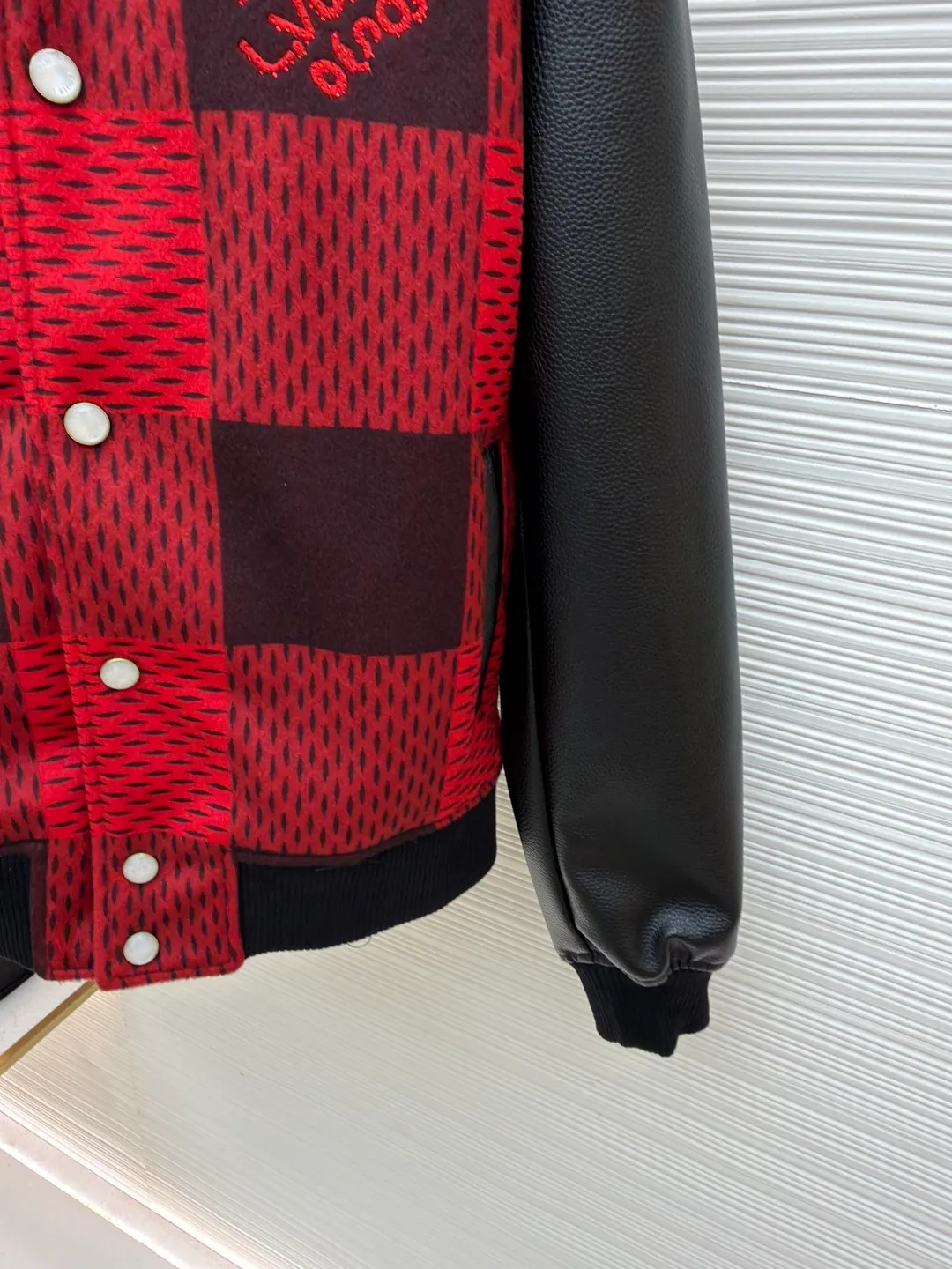 LOUIS VUITTON Plaid Logo Letter Beaded Embroidery Jacket ●Original version: Purchased and developed by 45646 ●Item number: 1681758-B95 ●Fabric: wool blended fabric ●Technology: Beaded embroidery production ●Color: red and black plaid ●Version: Fitted version ●Weight: about 1250 grams ●Size: 46-48-50-52 ●Description: The main body is made of contrasting plaid knitted fabric, with texture levels created through jacquard weaving technology. It is soft to the touch and has a crisp silhouette; the sleeves are spliced with matte leather and treated with scratch-resistant and wear-resistant treatment, giving it both texture and durability. The body of the garment is decorated with the brand's letter logo, using three-dimensional embroidery technology, with bright colors and clear texture to enhance recognition. The version is designed with a fitted baseball collar and is equipped with pearl button closure, making it easy to put on and take off. The ribbed collar, cuffs and hem enhance the fit and take into account windproofness and casual feel. The splicing of the whole garment adopts precision locking technology, with no exposed threads, and the size is measured manually (an error of 1-3CM is normal). The craftsmanship balances the softness of knitting and the toughness of leather, presenting the brand's trendy and advanced style. The overall wiring is straight and delicate, the fabric is comfortable and soft, and the color is consistent without color difference. It can be matched with the same style to create a fashionable look and control various occasions. Customized accessories, complete with three standards, same style for men and women!